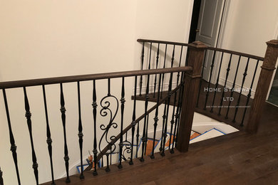 Modern wood curved metal railing staircase in Toronto with wood risers.
