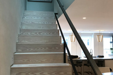 Diseño de escalera en L contemporánea grande con escalones de madera, contrahuellas de madera y barandilla de varios materiales