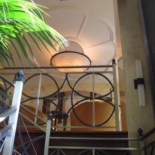Immagine di una grande scala sospesa eclettica con pedata in legno, alzata in legno e parapetto in metallo
