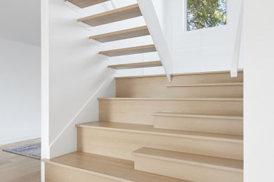 Inspiration for a mid-sized modern wooden u-shaped open and glass railing staircase remodel in Montreal