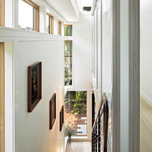 Immagine di una grande scala a rampa dritta design con pedata in legno, nessuna alzata e parapetto in metallo