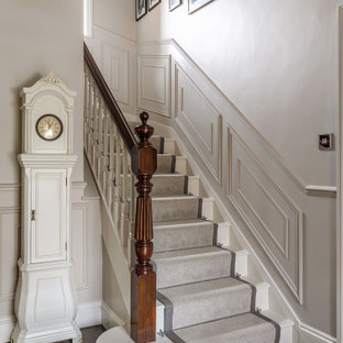 Mittelgroße Klassische Treppe in U-Form mit Teppich-Treppenstufen, Teppich-Setzstufen, Holzgeländer und vertäfelten Wänden in Essex