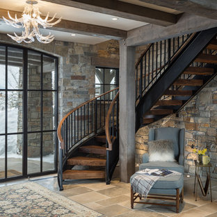 Example of a mountain style wooden curved open and mixed material railing staircase design in Jackson