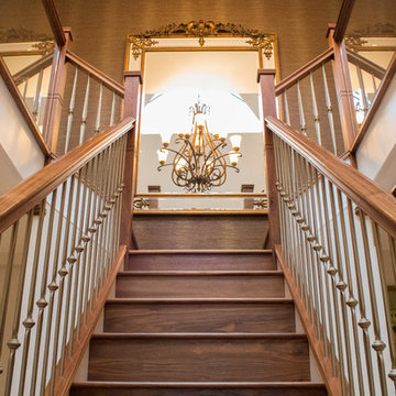 Walnut staircase with gold foged steel spindles and glass