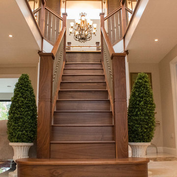 Walnut staircase with gold foged steel spindles and glass