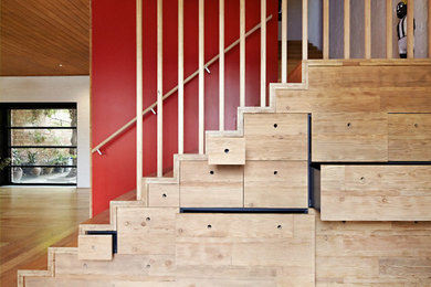 Exemple d'un escalier tendance en L avec des marches en bois, des contremarches en bois et rangements.