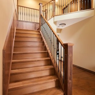Ejemplo de escalera en L, clásica, con escalones de madera, contrahuellas de madera y barandilla de varios materiales