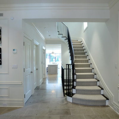 Example of a large classic wooden curved staircase design in New York with painted risers