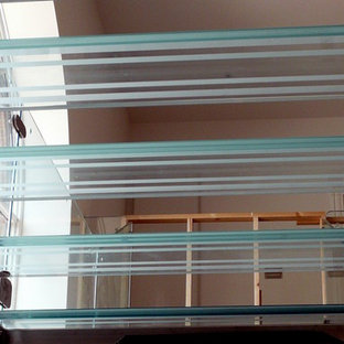 Foto di un'ampia scala sospesa design con pedata in vetro, alzata in vetro e parapetto in vetro