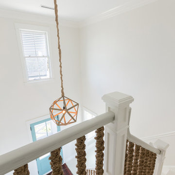White Home With Blue Entry Foyer and Rope Staircase