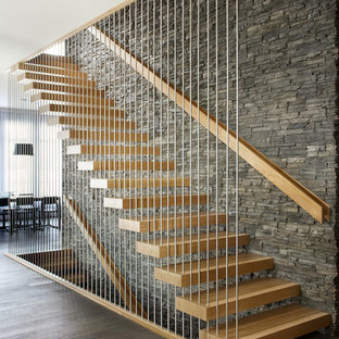 Foto de escalera suspendida, actual, sin contrahuella, con escalones de madera y barandilla de varios materiales