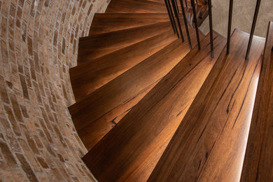 Example of a tuscan wooden curved wood railing staircase design in Other with wooden risers