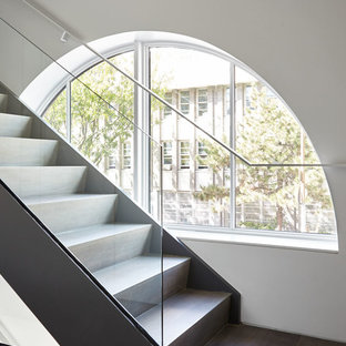 Esempio di una grande scala moderna con pedata in legno, alzata in legno e parapetto in vetro