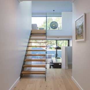 Mid-sized contemporary wood straight staircase in Sydney with glass railing and open risers.