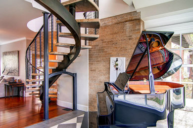 Example of a large minimalist wooden curved metal railing staircase design in Denver with wooden risers