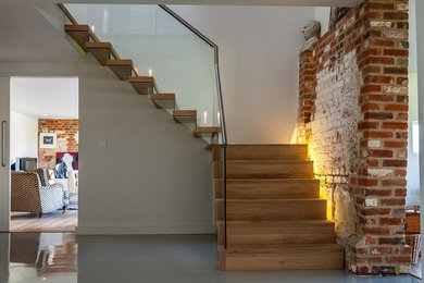 Photo of a modern wood straight staircase in Sussex with open risers.