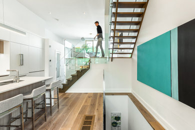 Inspiration for a contemporary wood floating glass railing staircase in Toronto with open risers.
