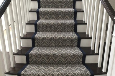 Staircase - mid-sized coastal carpeted curved staircase idea in New York with carpeted risers