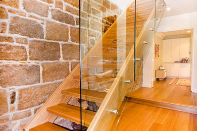Diseño de escalera recta tradicional renovada con escalones de madera, contrahuellas de madera y barandilla de vidrio