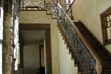 他の地域にある広いトラディショナルスタイルのおしゃれなかね折れ階段 (木の蹴込み板、混合材の手すり) の写真