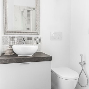 Foto di una stanza da bagno minimal con ante lisce, ante bianche, piastrelle nere, pareti bianche, lavabo a bacinella, pavimento grigio e top grigio