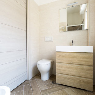 Ispirazione per una piccola stanza da bagno minimal con consolle stile comò, ante in legno chiaro, WC sospeso, piastrelle beige, pareti beige e pavimento beige