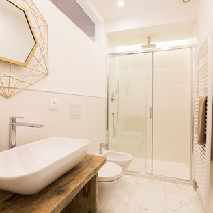 Immagine di una stanza da bagno con doccia mediterranea di medie dimensioni con nessun'anta, piastrelle bianche, pareti bianche, pavimento bianco, porta doccia scorrevole, piastrelle in ceramica, pavimento in marmo, lavabo a bacinella, top in legno, ante in legno scuro, doccia alcova, WC sospeso e top marrone