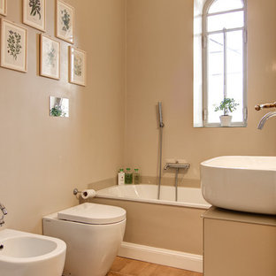 Esempio di una stanza da bagno padronale minimal di medie dimensioni con ante lisce, ante beige, vasca ad alcova, pareti beige, lavabo a bacinella, top in vetro, top beige, vasca/doccia, bidè, pavimento in legno massello medio, pavimento marrone e doccia aperta