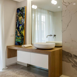 Foto di una stanza da bagno minimal con ante lisce, ante bianche, piastrelle bianche, lastra di pietra, pareti grigie, pavimento in cemento, lavabo a bacinella, top in legno, pavimento grigio e top marrone