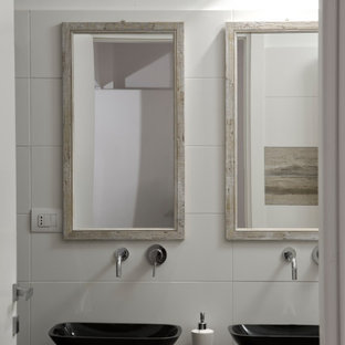 Foto di una stanza da bagno design con piastrelle bianche, lavabo a bacinella e top nero