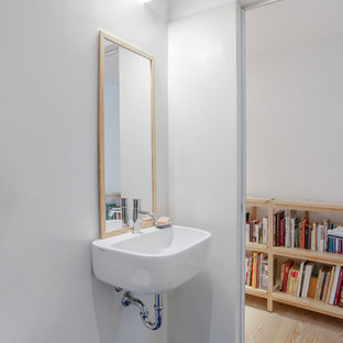 Foto di una stanza da bagno nordica con WC sospeso, pareti bianche, lavabo sospeso e pavimento blu