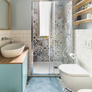 Idee per una stanza da bagno con doccia scandinava con ante lisce, ante blu, doccia alcova, WC sospeso, piastrelle bianche, piastrelle diamantate, pareti blu, lavabo a bacinella, top in legno, pavimento multicolore, porta doccia scorrevole e top marrone