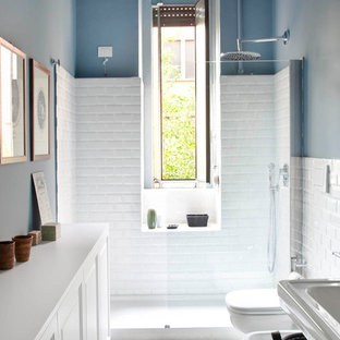 Ispirazione per una piccola stanza da bagno con doccia bohémian con pareti blu, pavimento multicolore, ante con riquadro incassato, ante bianche, doccia alcova, pavimento con piastrelle in ceramica e porta doccia a battente