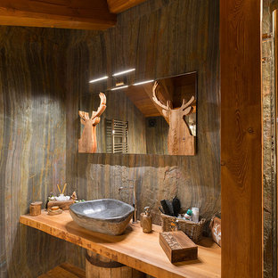 Ispirazione per una stanza da bagno rustica con pavimento in legno massello medio, lavabo a bacinella e top in legno