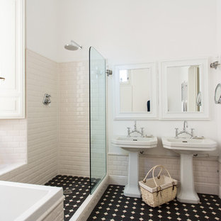 Esempio di una stanza da bagno padronale mediterranea con vasca da incasso, doccia ad angolo, piastrelle bianche, piastrelle diamantate, pareti bianche, lavabo a colonna, pavimento nero e doccia aperta