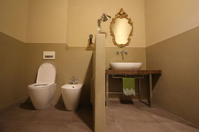 Diseño de cuarto de baño principal bohemio con armarios abiertos, puertas de armario de madera clara, ducha abierta, sanitario de una pieza, suelo de baldosas de porcelana, lavabo sobreencimera y encimera de madera