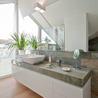 Ispirazione per una stanza da bagno contemporanea con ante lisce, ante bianche, pareti bianche, pavimento in legno massello medio, lavabo a bacinella, top piastrellato, pavimento marrone e top grigio