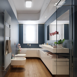 Inspiration för ett mellanstort funkis vit vitt en-suite badrum, med släta luckor, vita skåp, ett badkar i en alkov, en bidé, blå väggar, mellanmörkt trägolv, bänkskiva i kvarts, brunt golv och ett integrerad handfat