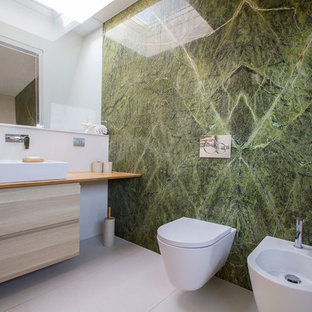 Immagine di una stanza da bagno minimal di medie dimensioni con WC sospeso, piastrelle verdi, piastrelle di marmo, pavimento in gres porcellanato, lavabo a bacinella, top in legno, pavimento beige, top beige, ante lisce, ante in legno chiaro e pareti bianche