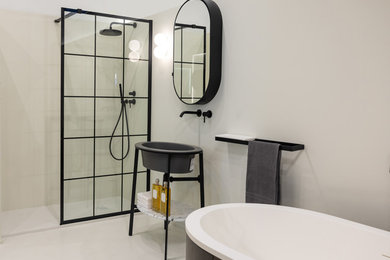 Immagine di una grande stanza da bagno con doccia minimal con vasca freestanding, zona vasca/doccia separata, pareti beige, lavabo a consolle, pavimento beige e doccia aperta