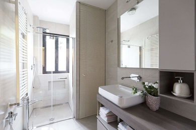 Immagine di una piccola stanza da bagno con doccia minimalista con doccia a filo pavimento, WC sospeso, pareti beige, pavimento in gres porcellanato, lavabo a bacinella e pavimento beige