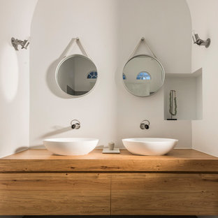 Esempio di una stanza da bagno minimal con ante in legno scuro, top in legno, pavimento grigio, ante lisce, pareti bianche, lavabo a bacinella e top beige