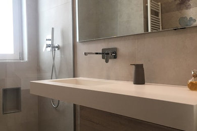Immagine di una stanza da bagno con doccia minimalista con ante in legno chiaro, piastrelle beige, piastrelle in gres porcellanato, pareti beige, pavimento in gres porcellanato, lavabo integrato, top in superficie solida, pavimento beige e top bianco