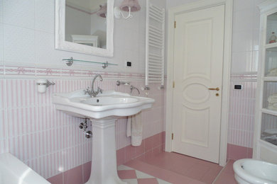 Idee per una stanza da bagno padronale shabby-chic style di medie dimensioni con ante di vetro, ante bianche, vasca da incasso, WC a due pezzi, piastrelle rosa, piastrelle in ceramica, pareti multicolore, pavimento in gres porcellanato, lavabo a colonna e pavimento rosa