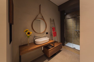 Ispirazione per una stanza da bagno design di medie dimensioni con ante marroni, pareti beige, lavabo a bacinella, top in legno, pavimento beige, porta doccia scorrevole, top marrone e un lavabo
