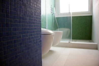 Ispirazione per una stanza da bagno padronale design di medie dimensioni con doccia a filo pavimento, WC sospeso, piastrelle verdi, piastrelle a mosaico, pareti verdi, pavimento con piastrelle in ceramica, lavabo a bacinella e top piastrellato
