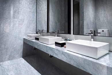 Foto di una stanza da bagno minimalista con piastrelle grigie, piastrelle in gres porcellanato, pareti grigie, pavimento in gres porcellanato, top piastrellato, pavimento grigio e top grigio