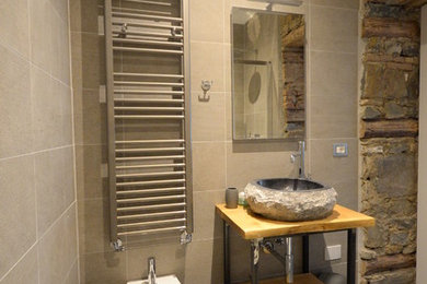 Ispirazione per una stanza da bagno con doccia design di medie dimensioni con ante in legno chiaro, WC sospeso, piastrelle grigie, piastrelle in gres porcellanato, pavimento in gres porcellanato, lavabo a bacinella, top in legno e pavimento grigio