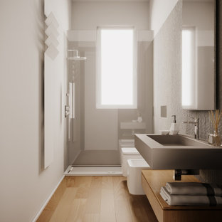 Inspiration for a small contemporary 3/4 bathroom in Milan with flat-panel cabinets, light wood cabinets, a curbless shower, a wall-mount toilet, gray tile, porcelain tile, white walls, porcelain floors, a drop-in sink, solid surface benchtops, a sliding shower screen, white benchtops, a single vanity, a floating vanity and recessed.