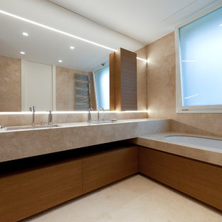 Esempio di una stanza da bagno padronale moderna con ante in legno scuro, lavabo sottopiano, ante lisce, vasca sottopiano, piastrelle beige, pareti beige, pavimento beige e top beige